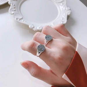 Detailed view of vintage S925 sterling silver rings with floral and portrait relief