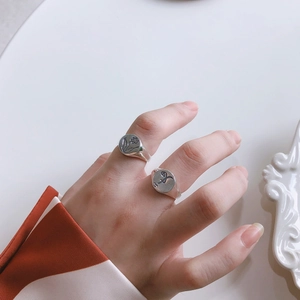 Close-up of S925 silver rings with engraved floral patterns worn on human fingers