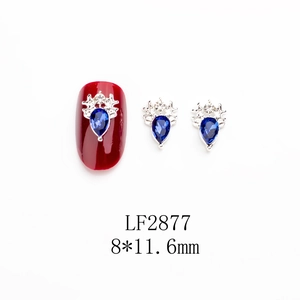 Détail de bijou d'ongle couronne en argent avec zircon bleu en goutte et diamants