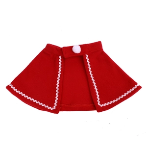 Detailed view of red Christmas pet cape with white scalloped trim and fluffy pom-pom
