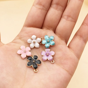 Five colored enamel flower charms in palm, gold-plated jewelry making accessories