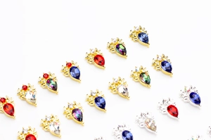 Vue macro de cristaux d'ongles en goutte colorés avec montures en métal doré et argent