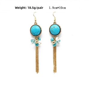 Detail of ethnic turquoise tassel earrings with blue stones and golden metal chain