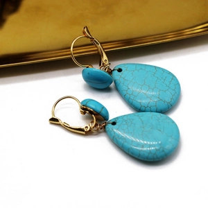 Detail of teardrop turquoise earrings with gold French wire hooks and stone texture
