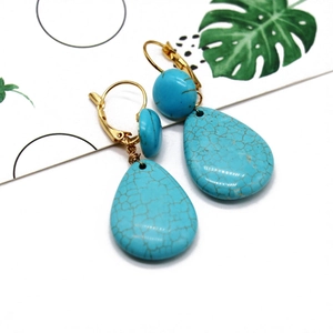 Detail of bohemian turquoise teardrop earrings with gold plating and vintage stone texture