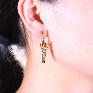 Detailed view of bicolor lovers hug earrings in gold and silver finish on model