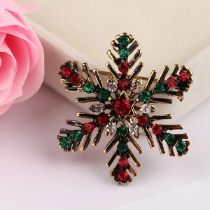 Detailed macro of vintage gold snowflake brooch with red, green, and clear rhinestones