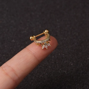 Golden micro-pave zircon screw earring held on fingertip for size perspective