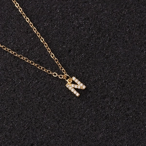 Macro shot of gold letter N pendant necklace with inlaid cubic zirconia and O-chain