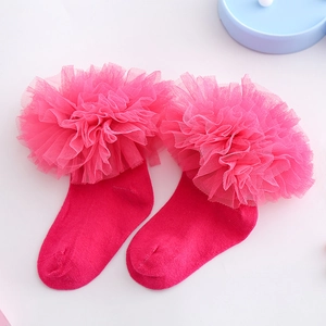 Detailansicht von rosa Baumwoll-Babysocken mit flauschigen Rüschen aus Netzspitze