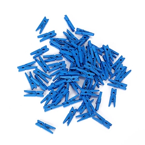 Close-up of scattered blue small wooden clips for photo decoration and craft use
