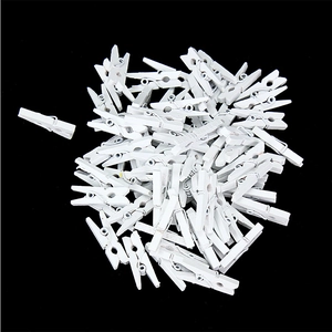 Pile of small white wooden clips with metal springs isolated on a black background