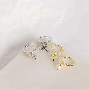Macro detail of dragonfly drop earrings in gold and silver finish with zircon stones