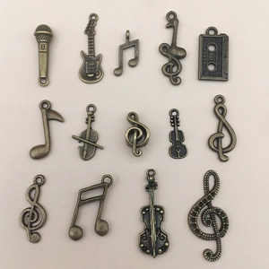 Detail of vintage bronze music themed charms including guitar, violin and music notes