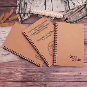 Three retro kraft paper notebooks with black spiral binding on a vintage wooden desk
