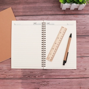Minimalist kraft paper spiral notebook with lined pages on a dark wooden desk