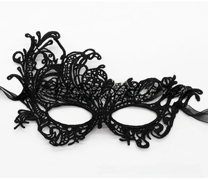 Detail of black lace masquerade mask with intricate hollow floral embroidery and silk ribbons