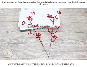 Detail of red artificial berry stems for Christmas DIY flower arrangements on books