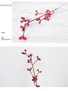 Close-up of bright red artificial berry branches in a vase for home holiday decoration