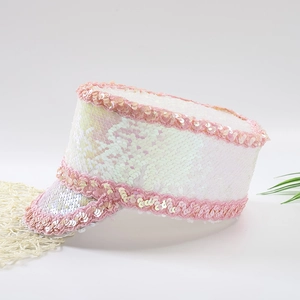 Detail of white sequined captain hat with pink trim and shimmering iridescent finish