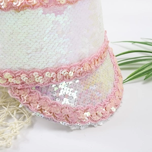 Close-up of sparkling white sequins and pink lace trim on a stylish party hat