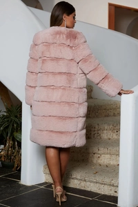 Rear view of a long pink faux fur coat with horizontal paneling on a female model
