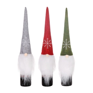 Three Nordic Christmas gnomes wine bottle covers in red, grey, and green with snowflake hats