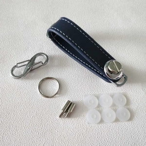 Blue leather key organizer parts showing stitching, metal D-ring, screws and washers