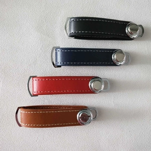 Flat lay of leather key organizers in black, blue, red, and brown with metal snaps