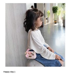 Bambina indossa mini borsa a tracolla in tweed rosa con coniglietto e catena dorata