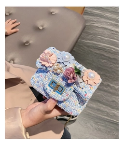 Dettaglio borsa bimbo in tweed blu con fiori di perle e chiusura a scatto oro