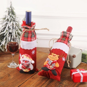 Santa Claus and reindeer wine bottle covers on wooden table with Christmas decor