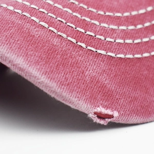 Detailed macro view of vintage washed cotton baseball cap brim with distressed holes