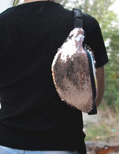 Rose gold sequined fanny pack worn as a crossbody bag by a model, back view detail