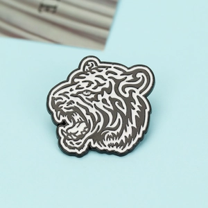 Detail of creative tiger head brooch with black and white enamel finish on alloy metal base