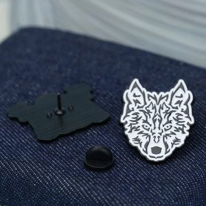 Macro view of white lion head enamel brooch on denim with black rubber backings