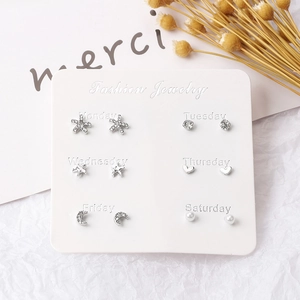 Detail of 6 pairs of silver earrings set featuring stars, moons, and pearls on a card