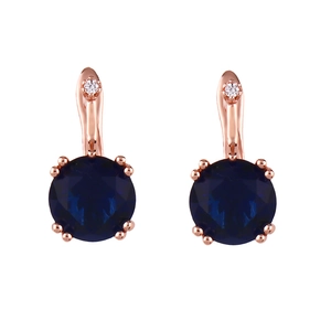 Détail de boucles d'oreilles créoles en or rose avec zircons bleus ronds polis