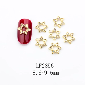 Macro view of gold alloy star nail charms with colorful rhinestones measuring 8.6x9.6mm