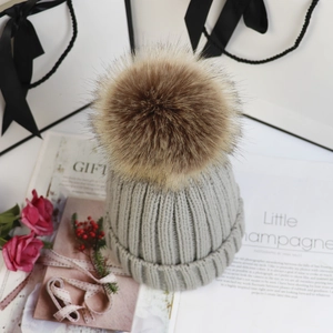 Detailansicht der grauen Strickmütze mit Kunstpelz-Bommel in stilvollem Geschenk-Set