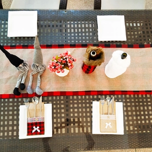 Detail of Christmas table runner set with red plaid gnomes and wine bottle covers