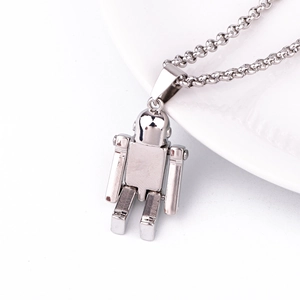 Silver robot pendant necklace with polished finish displayed on a white plate edge
