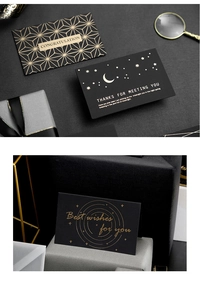 Detailed view of black cards with gold foil text and elegant rectangular designs