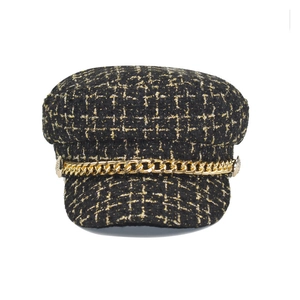 Detail of black and gold plaid tweed baker boy hat with metallic chain and side buttons