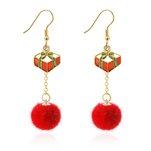 Detail of festive gold earrings featuring red gift box charms and soft red plush pom-poms
