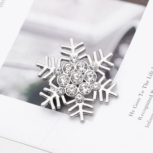 Macro view of a silver snowflake brooch with sparkling crystals on a textured paper