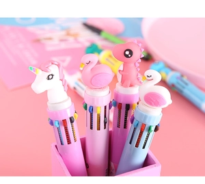 Close-up of cute cartoon dinosaur and unicorn toppers on multi-color retractable pens