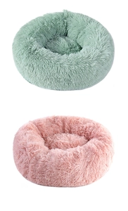 Close-up of soft faux fur texture and thick padding on round plush pet beds in pink and green