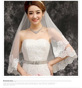 Close-up of elegant white single-layer lace bridal veil with intricate floral embroidery edges