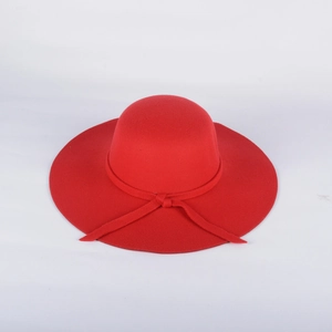 Détail d'un chapeau en feutre de laine rouge à bord large avec un nœud décoratif